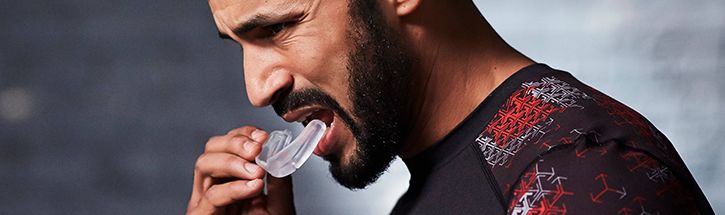 Homem colocando protetor bucal para treino de boxe