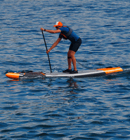 Homem em preparação para remadas de longa distância no mar com colete salva vidas e boné